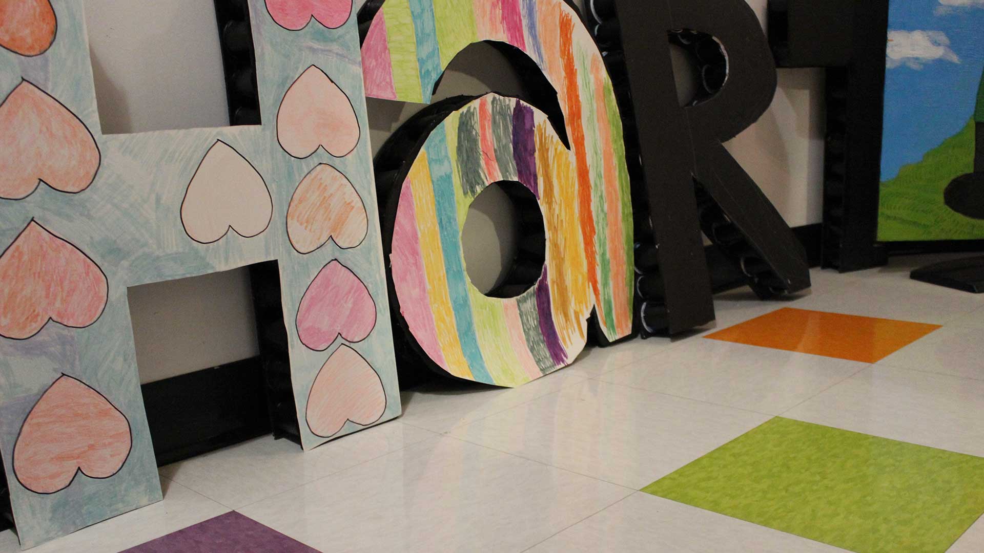 Huge letters spelling H'art in a hallway