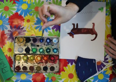 Brush in hand above watercolour palette